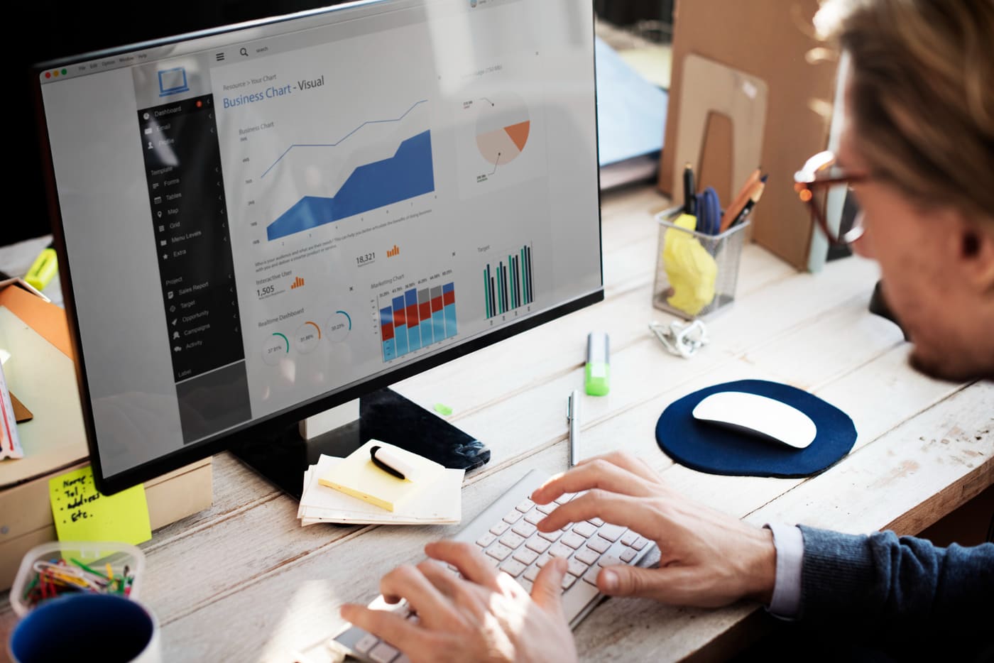 An analyst studying business charts on screen